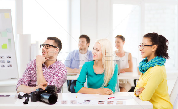 Stock photo: smiling team with photocamera working in office