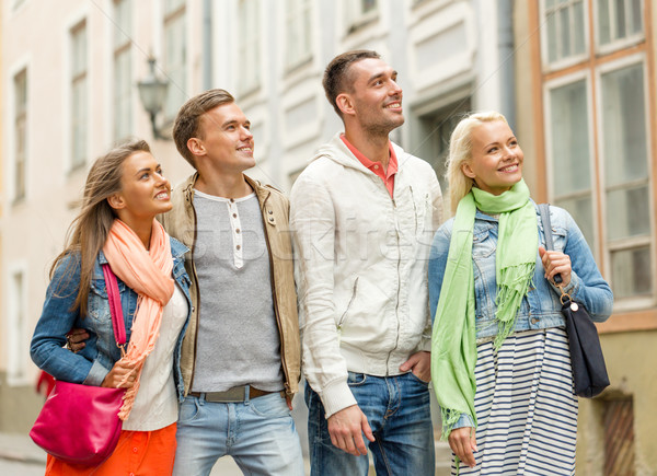 group of smiling friends walking in the city Stock photo © dolgachov