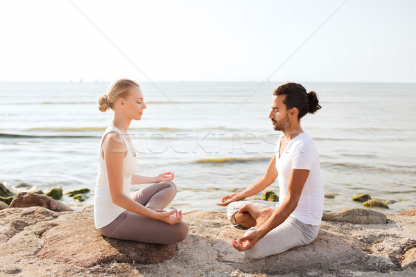 smiling couple making yoga exercises outdoors Stock photo © dolgachov