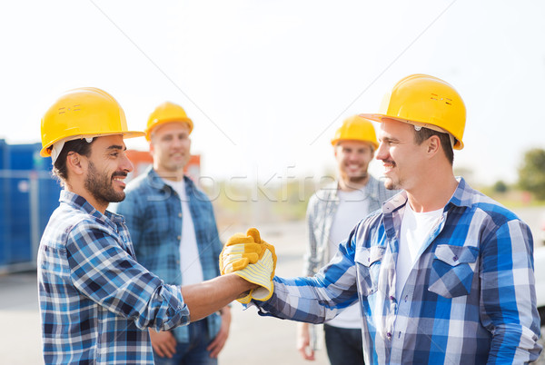 Groupe souriant constructeurs serrer la main extérieur affaires Photo stock © dolgachov