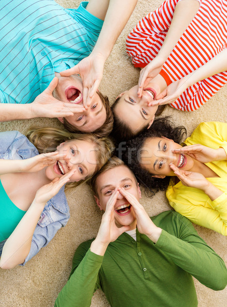 smiling people lying down on floor and screaming Stock photo © dolgachov