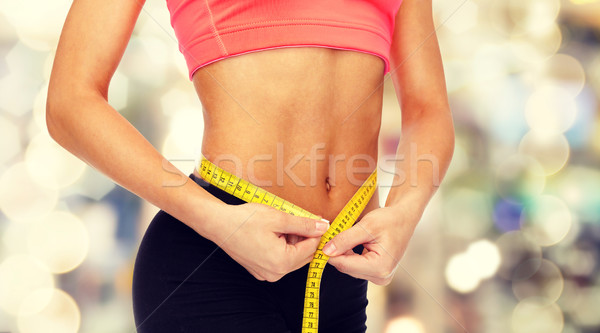 Stock photo: close up of female hands measuring waist