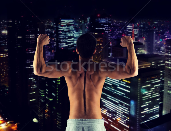 Stock photo: young man showing biceps and muscles