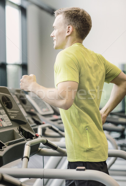 Zâmbitor om banda de alergare sală de gimnastică sportiv Imagine de stoc © dolgachov
