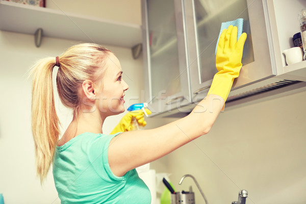 happy woman cleaning cabinet at home kitchen Stock photo © dolgachov