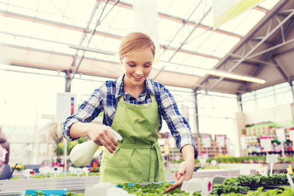 woman with sprayer and seedling in greenhouse Stock photo © dolgachov