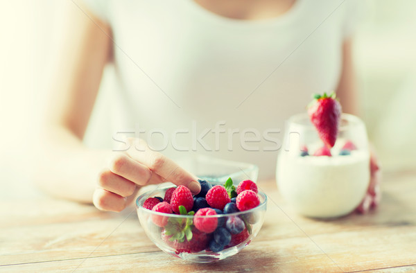 close up of woman hands with yogurt and berries Stock photo © dolgachov