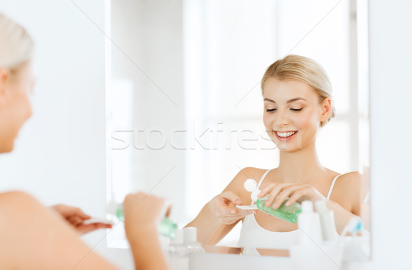 Młoda kobieta mleczko kosmetyczne mycia twarz łazienka piękna Zdjęcia stock © dolgachov