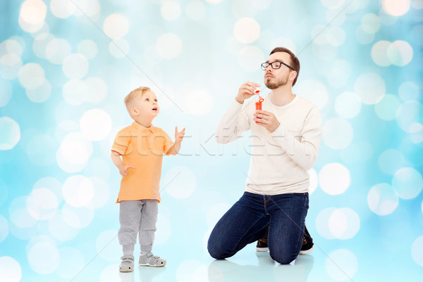 father with son blowing bubbles and having fun Stock photo © dolgachov