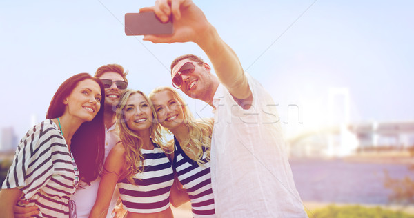 happy friends taking selfie by smartphone in tokyo Stock photo © dolgachov