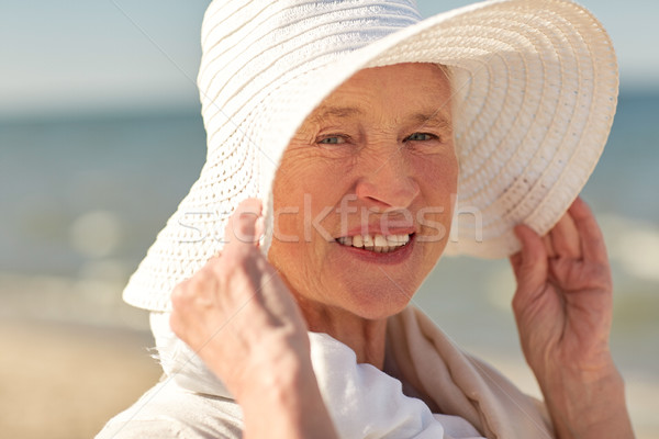 happy senior woman in sun hat on summer beach Stock photo © dolgachov