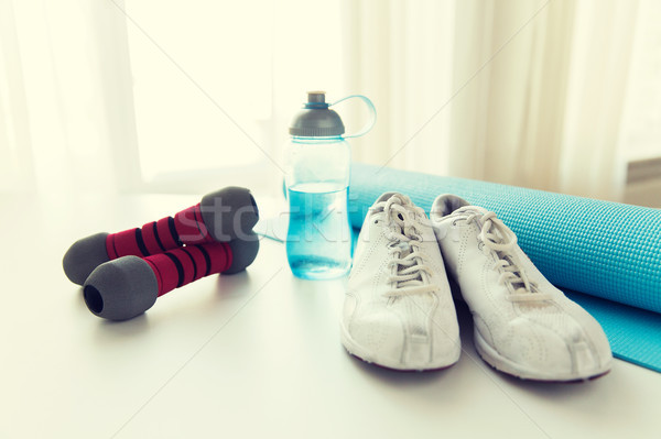close up of bottle, dumbbells, sneakers and mat Stock photo © dolgachov