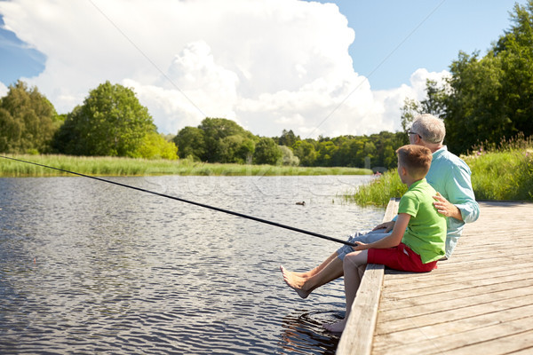 Stock photo: grandfather and grandson fishing on river berth