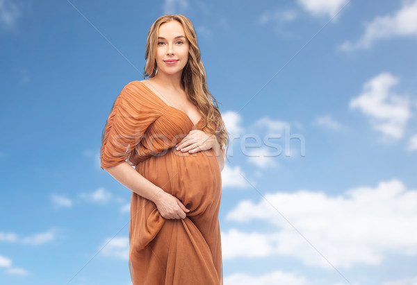 happy pregnant woman touching her belly over sky Stock photo © dolgachov