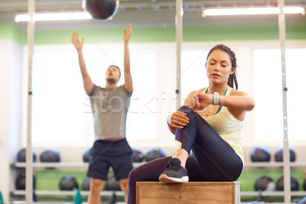 man and woman with ball and fitness tracker in gym Stock photo © dolgachov