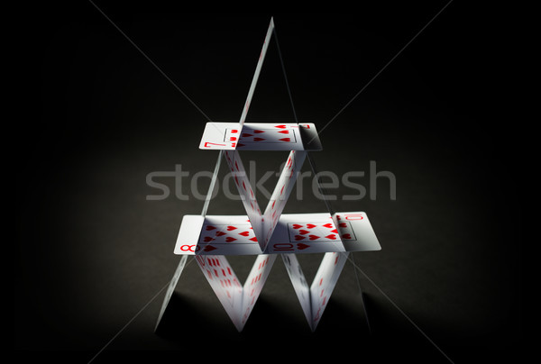 house of playing cards over black background Stock photo © dolgachov