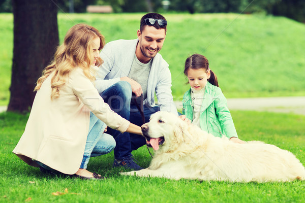 Stock photo: happy family with labrador retriever dog in park