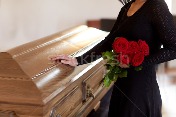 woman with red roses and coffin at funeral Stock photo © dolgachov