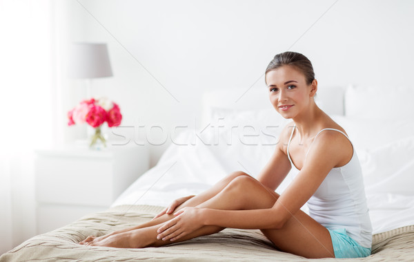 beautiful woman with bare legs on bed at home Stock photo © dolgachov