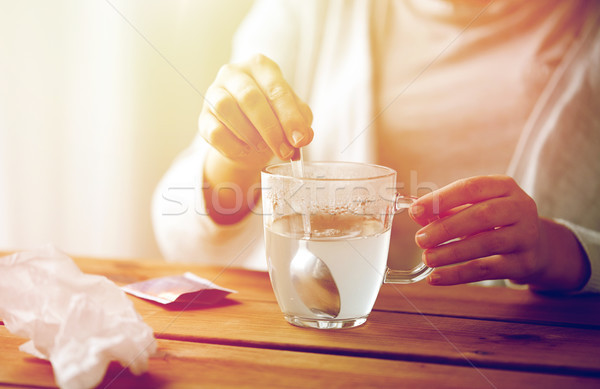 woman stirring medication in cup with spoon Stock photo © dolgachov