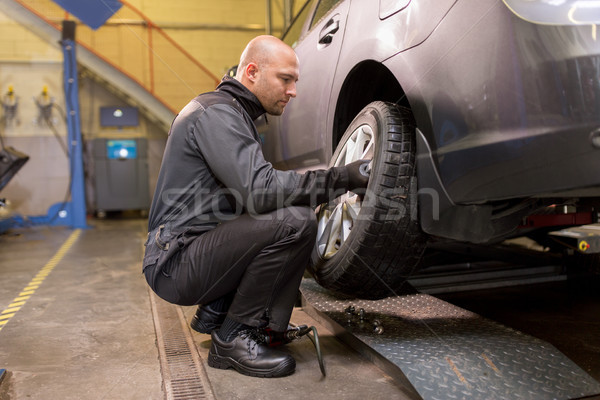 auto mechanic changing car tire at workshop Stock photo © dolgachov