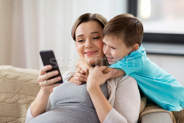 Gravidă mamă smartphone acasă familie Imagine de stoc © dolgachov