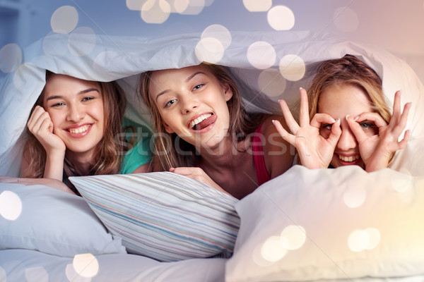 happy young women in bed at home pajama party Stock photo © dolgachov
