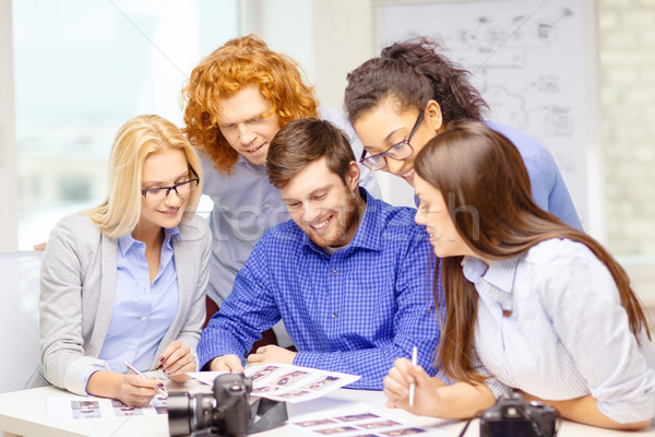 Stock photo: smiling team with photocamera and images in office