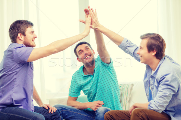 Uśmiechnięty mężczyzna znajomych high five domu zespołowej Zdjęcia stock © dolgachov
