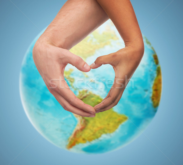 human hands showing heart shape over earth globe Stock photo © dolgachov