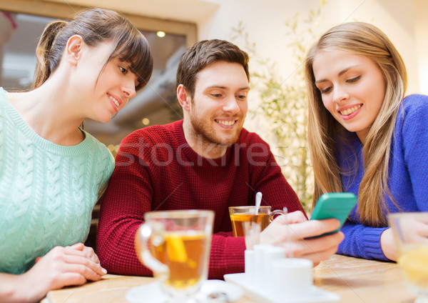 group of friends with smartphone meeting at cafe Stock photo © dolgachov