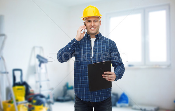 smiling builder in helmet calling on smartphone Stock photo © dolgachov