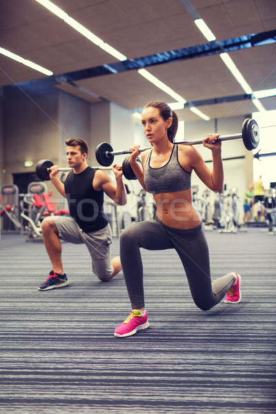 young man and woman training with barbell in gym Stock photo © dolgachov