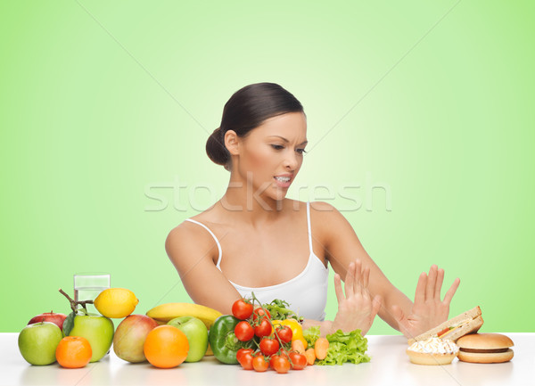 woman with fruits rejecting hamburger Stock photo © dolgachov