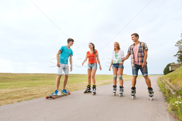 happy teenagers with rollerblades and longboards Stock photo © dolgachov