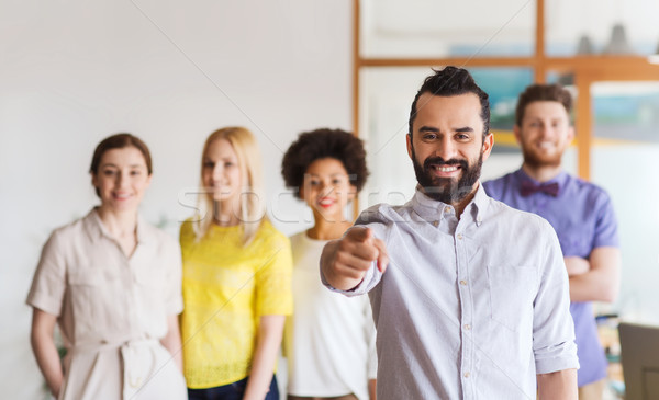 Stock photo: happy man pointing finger at you over office team