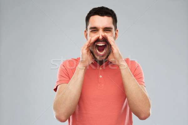 angry shouting man in t-shirt over gray background Stock photo © dolgachov