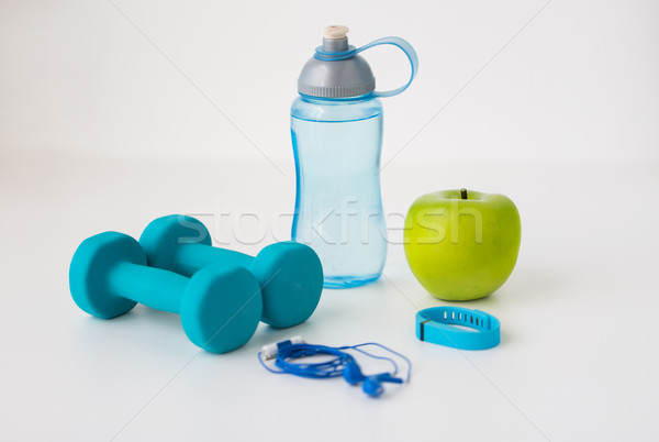 Stock photo: dumbbells, fitness tracker, earphones and bottle