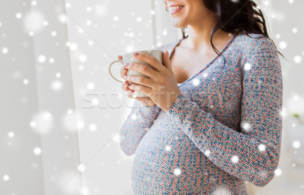 close up of pregnant woman with tea cup at window Stock photo © dolgachov