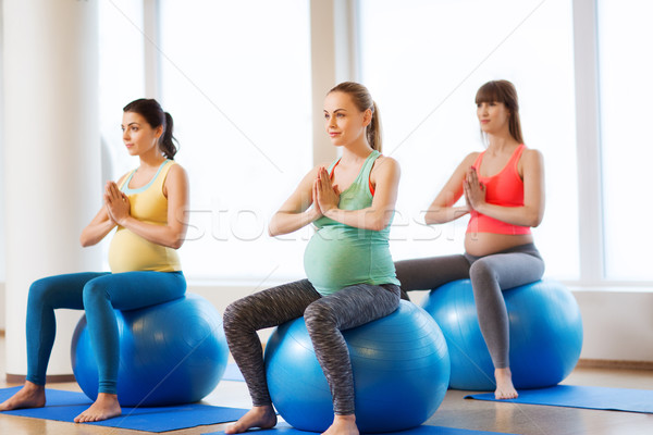 happy pregnant women exercising on fitball in gym Stock photo © dolgachov