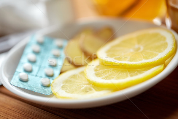 lemon slices, pills and ginger on plate Stock photo © dolgachov