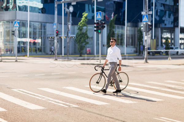 young man with bicycle on crosswalk in city Stock photo © dolgachov