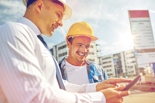 happy builders in hardhats with tablet pc outdoors Stock photo © dolgachov