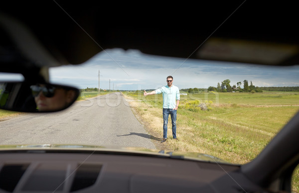 man hitchhiking and stopping car with thumbs up Stock photo © dolgachov