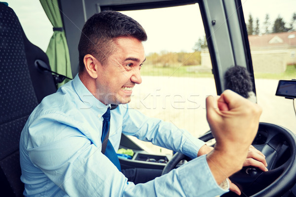 angry driver showing fist and driving bus Stock photo © dolgachov