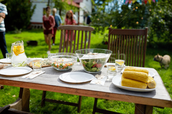 people coming to table with food at summer garden Stock photo © dolgachov