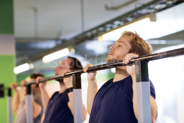 group of young men doing pull-ups in gym Stock photo © dolgachov