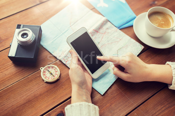 Stock photo: close up of traveler hands with smartphone and map