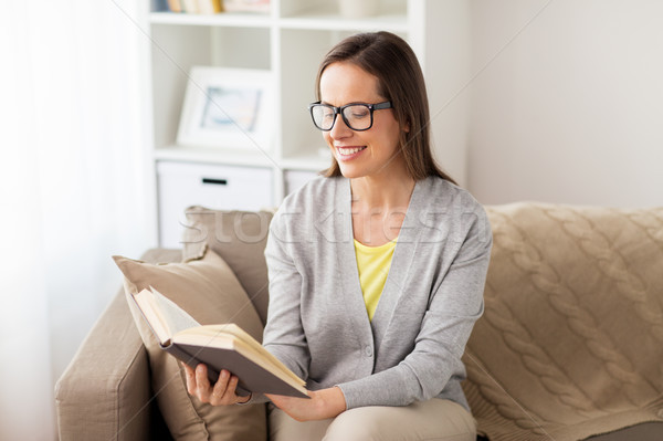 young woman in glasses reading book at home Stock photo © dolgachov