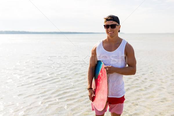 happy young man with skimboard on summer beach Stock photo © dolgachov